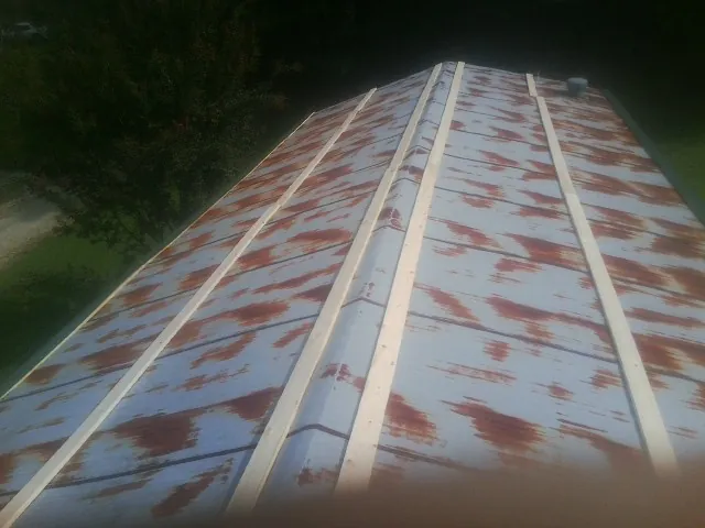 Rusted metal roof panels with new wood purlins before replacement — Storm Damage Roof Repair in Barstow by Roofing Brothers