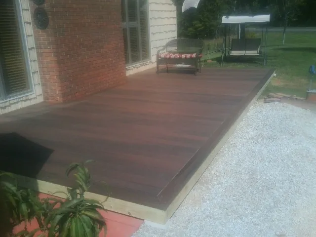 Freshly stained wood deck built against a brick home in Barstow