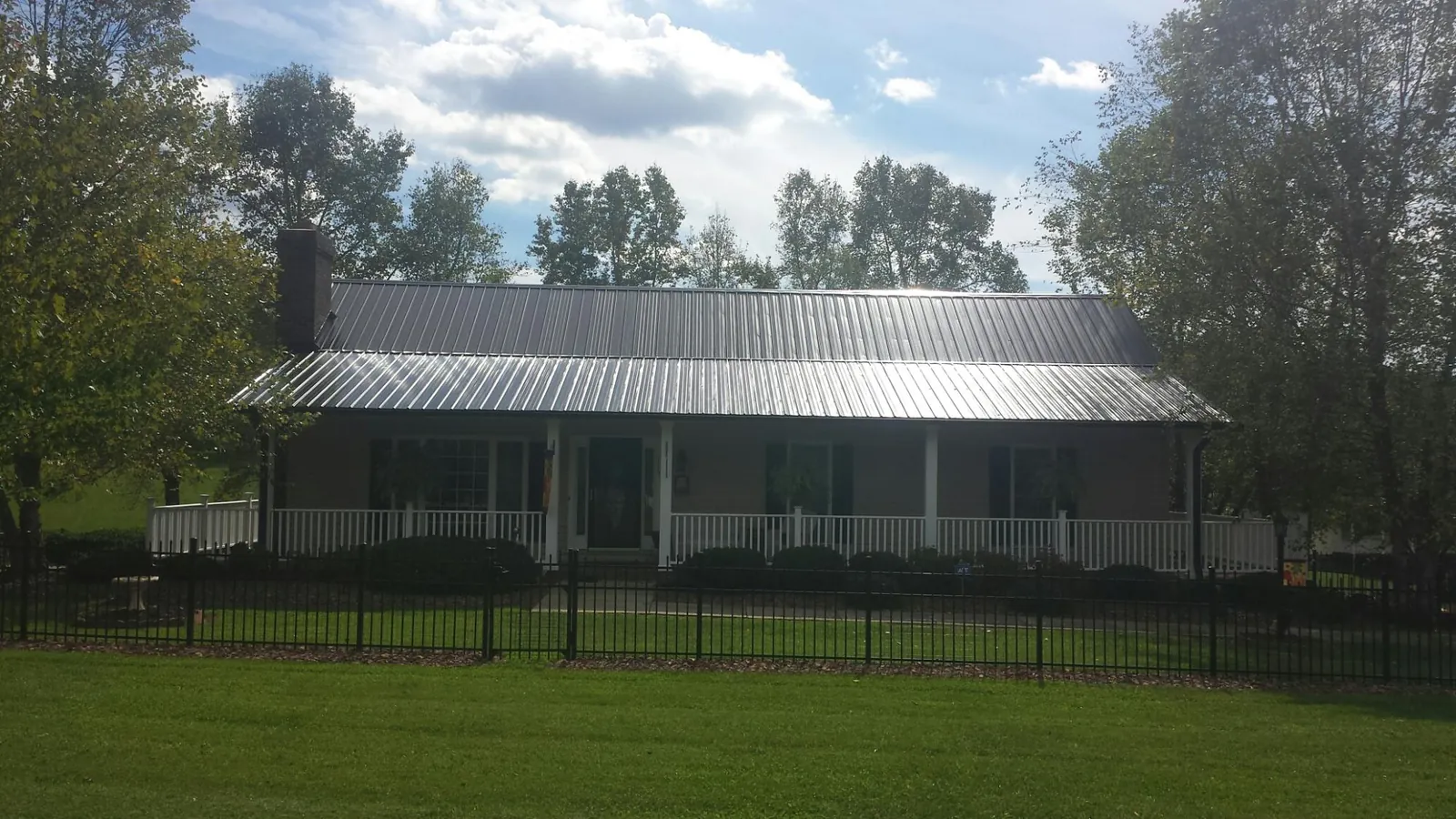 Gray metal roof on a brick ranch with a full width front porch — Gutter Guard Installation work by our crew in Barstow