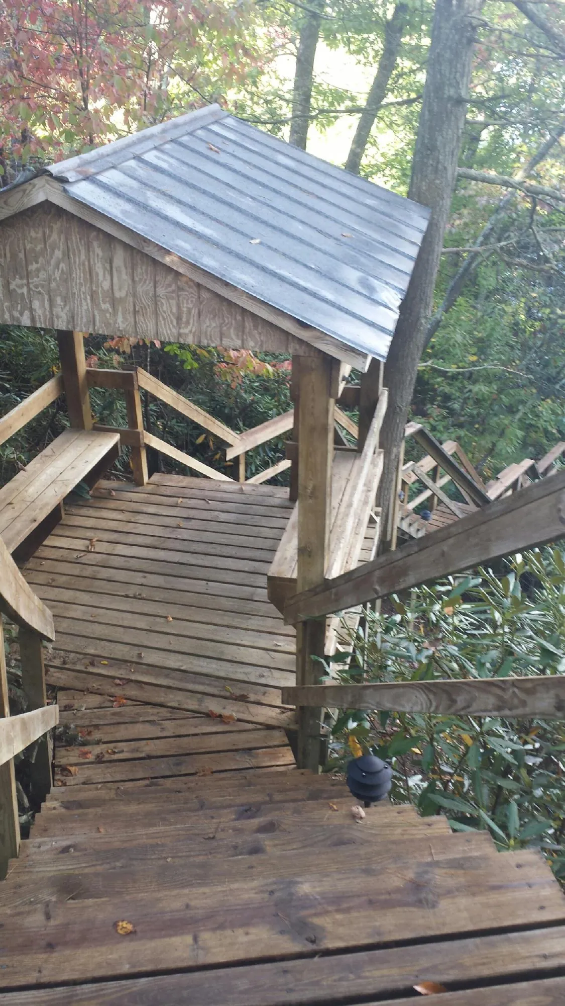 Metal roofed shelter over wooden steps on a wooded walkway — Skylight Repair & Installation work by our crew in Barstow