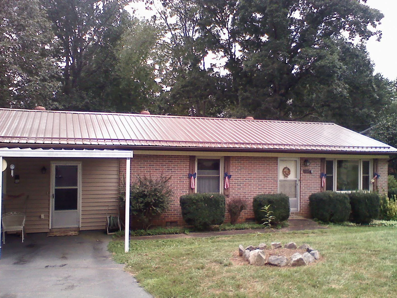Bronze metal roof and carport on a brick ranch home — Roof Repair work by our crew in Barstow